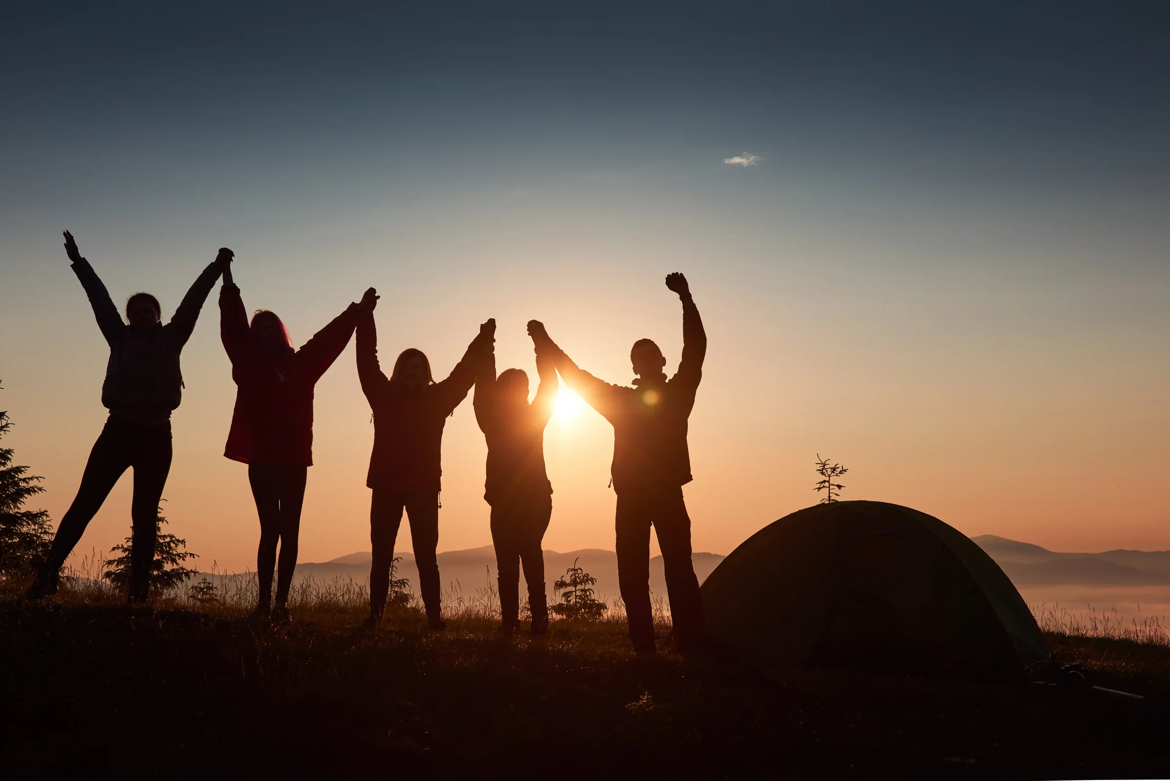 A community celebrating connection and growth at sunset